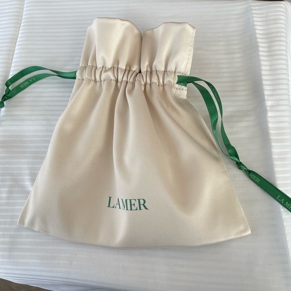 La Mer Handbags - La Mer. Cream Satin Pouch. New, unused.Great for makeup, jewelry, or accessories